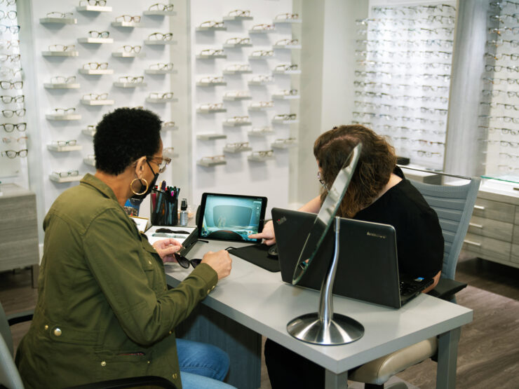 A doctor showing a patient a screen that displays a lens.