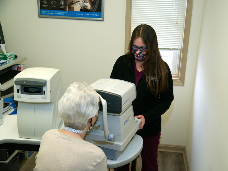 A doctor examines a patient's eyes through eye exam equipment.