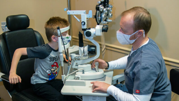 A doctor examines a young boy's eyes.