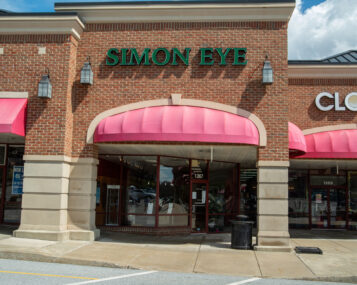 A brick building with Simon Eye in large green letters on the front store-face.