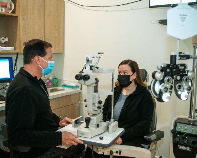 A patient and a doctor with eye examination equipment.