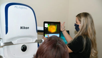 A doctor shows a medical screen displaying backlit images of an eye.