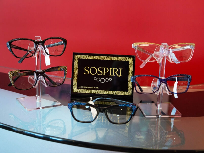 Five pairs of glasses on display along with a display of the Sospiri logo.