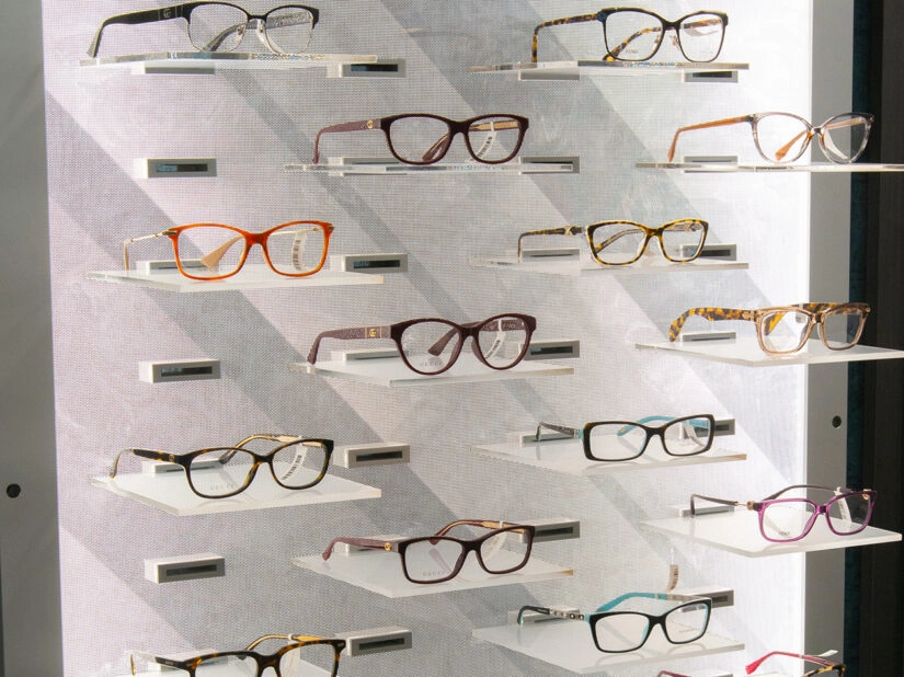 Glasses displayed in a backlit display case on a wall.