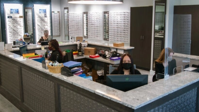 Three people working at the front desk of Simon Eye Wilmington.