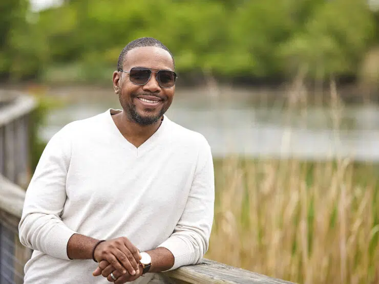 A man wearing sunglasses smiling.