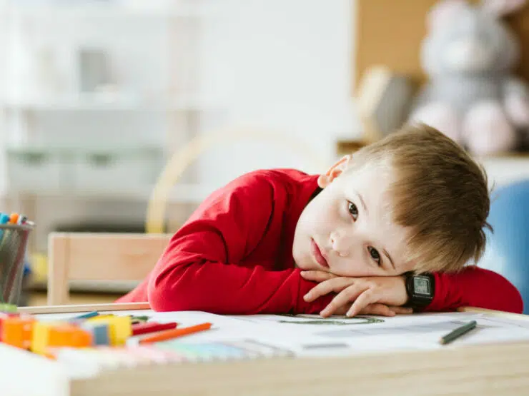 Child laying head on a arms on a table