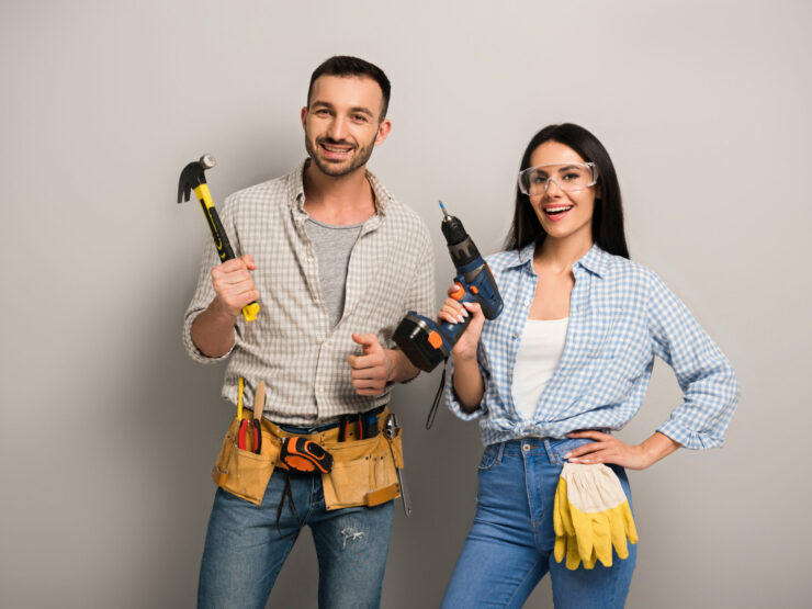 2 Excited manual workers holding tools and a power drill.