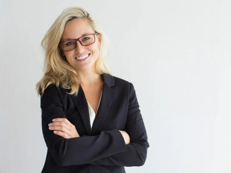 woman in a black jacket wearing glasses and smiling