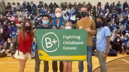 Group of people holding a "Fighting Childhood Cancer" banner.