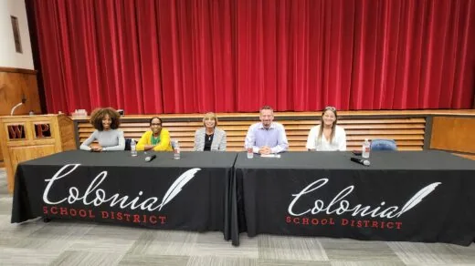 group of people sitting at tables in auditorium