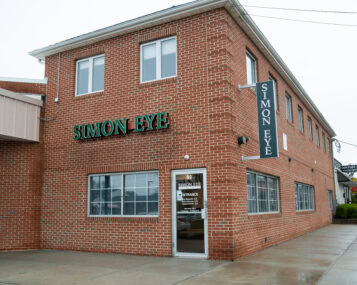 A brick building with Simon Eye in large green letters on the front store-face.