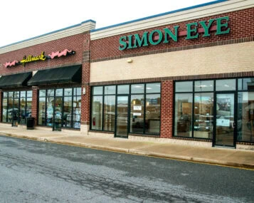 A brick building with Simon Eye in large green letters on the front store-face.