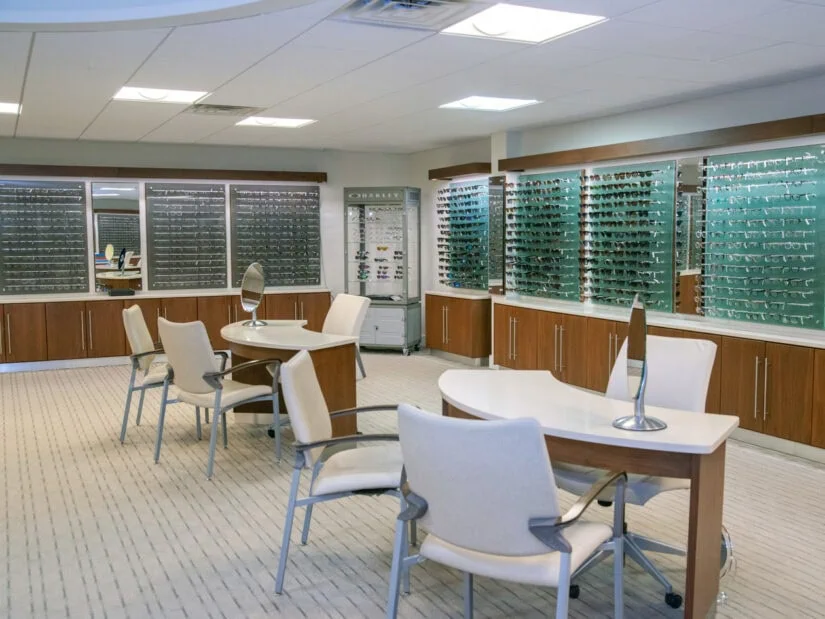 Empty desks and chairs, along with glasses on wall mounted displays.