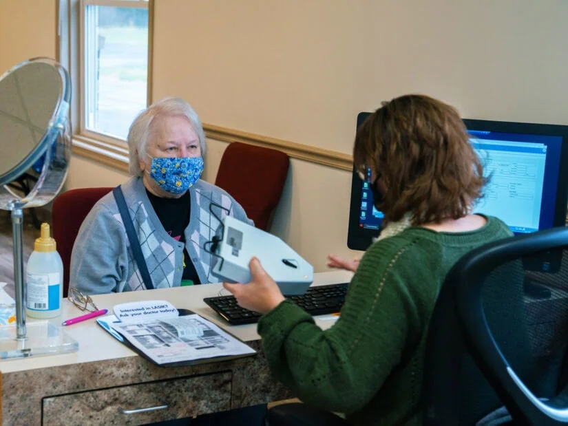 A patient sitting in front of a doctor at a desk.