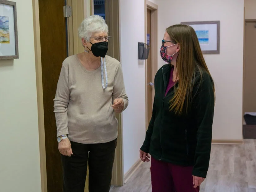 A doctor and a patient in a hallway.