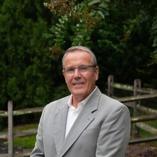man in a grey suit with eye glasses on