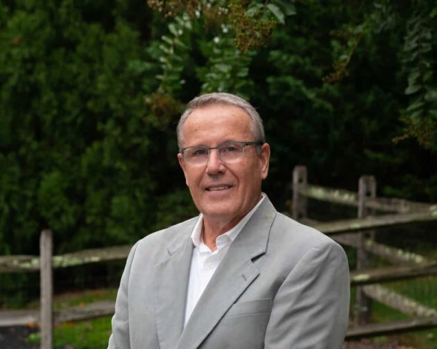 man in a grey suit with eye glasses on