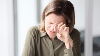 Exhausted, tired female manager sitting with her eyes closed at her desk in office.